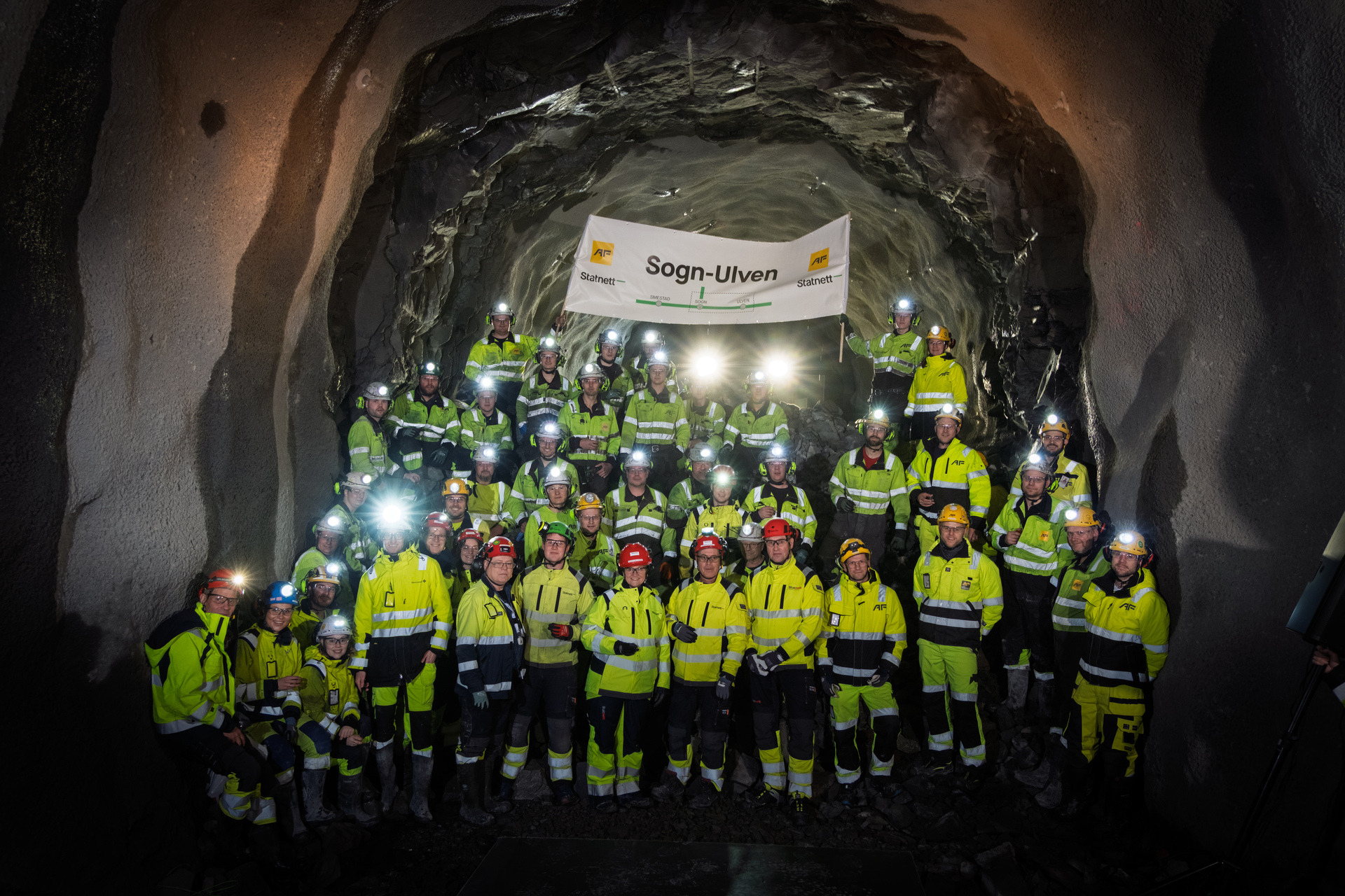 Fellesbilde av folk i verneklær i tunnel