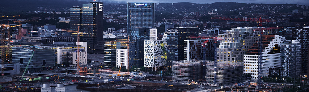 Oslo by med store lysende byggninger om kvelden 